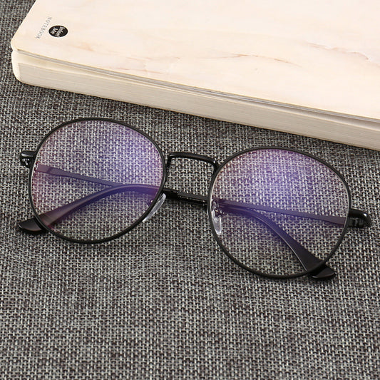 Black round anti-blue light glasses with clear lenses showing a blue reflection, resting on a gray textured surface. - Image 2