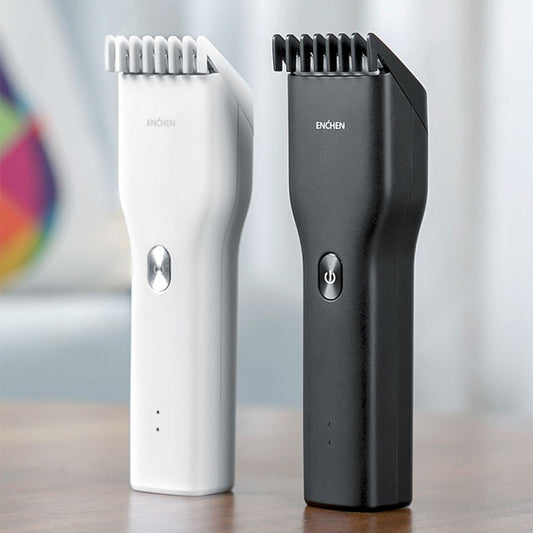 Black cordless hair shaver with a comb attachment and two white indicator lights, with a blurred white shaver in the background.