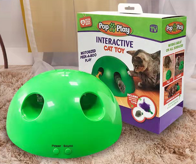 A cute tabby and white kitten with green eyes playing with a bright green dome-shaped interactive cat toy. - Image 2