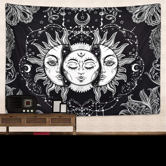 Black and white tapestry with a celestial design featuring three faces of the sun and moon, surrounded by stars and floral patterns.
