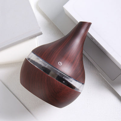 Teardrop-shaped humidifier with light wood grain finish and clear water tank, featuring a power button icon. - Image 3
