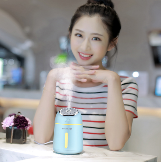 Light blue mini ultrasonic humidifier with a silver top, power button, and clear water level indicator. - Image 4