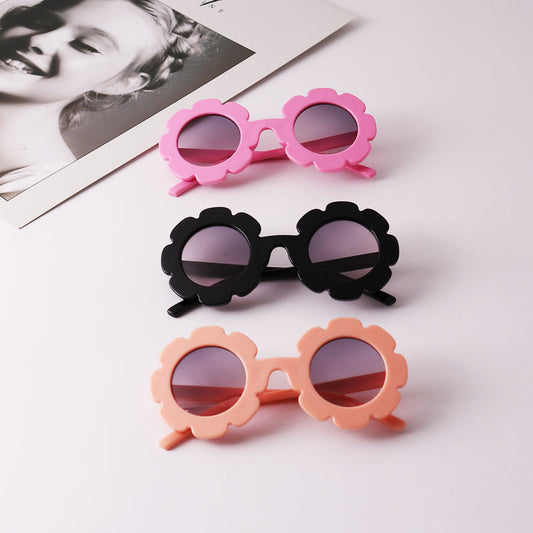 Light blue flower-shaped sunglasses with dark lenses, featuring a playful design and plastic frame.