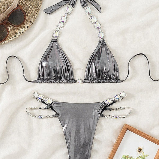 Shiny blue two-piece bikini with rhinestone-embellished halter top and high-cut bottom, laid flat with a straw hat and sunglasses. - Image 4