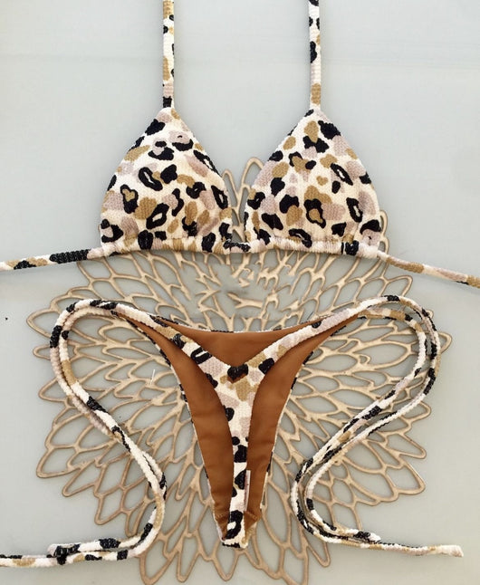 White textured bikini with red cherry print, featuring a triangle top and tie-side bottoms, on a woven mat. - Image 7