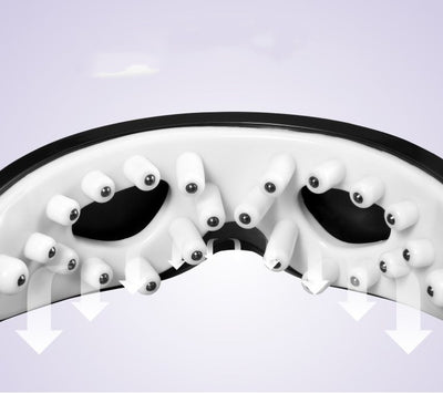 White and black eye massager with a goggle-like design, featuring a white frame and dark lenses, on a wooden surface. - Image 5