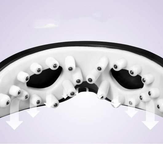 White and black eye massager with a goggle-like design, featuring a white frame and dark lenses, on a wooden surface. - Image 5