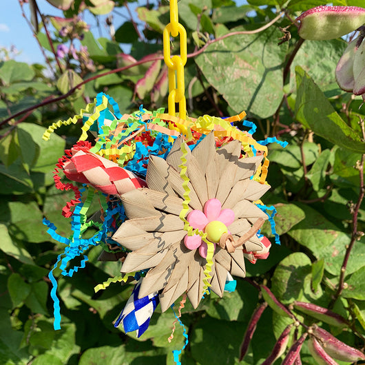 Colorful parrot chew toy made from natural fibers, featuring a woven ball, leaf-like accents, a bell, and a carabiner clip. - Image 3