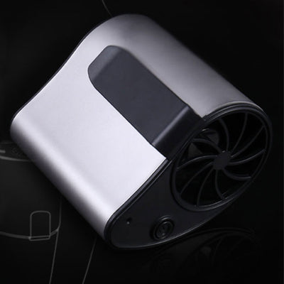 Close-up of a finger pressing the power button on a silver-grey portable waist fan with a black fan grill. - Image 3