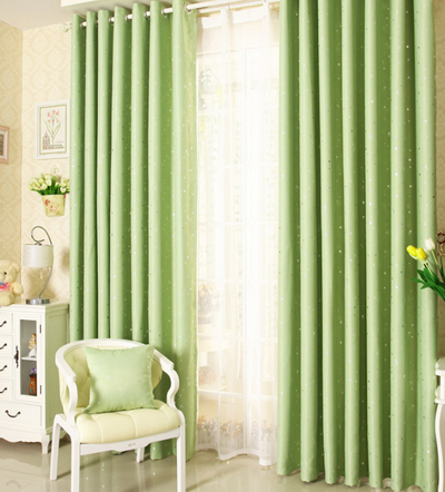 Blue star print curtains tied back to reveal sheer white curtains, in a bright room with a white chair. - Image 10