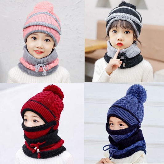 Young child wearing a pink and grey knitted hat with a pom-pom and a matching neck warmer with a drawstring.
