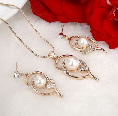 Gold-toned heart-shaped necklace and dangle earrings set with clear rhinestones and faux pearls. - Image 5