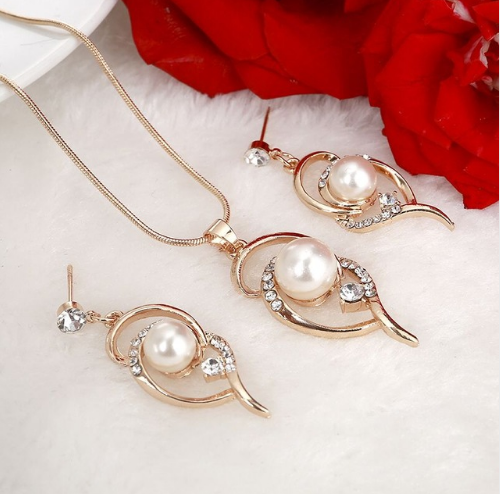 Gold-toned heart-shaped necklace and dangle earrings set with clear rhinestones and faux pearls. - Image 5