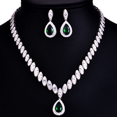 Silver-toned necklace and earring set with red teardrop stones and clear marquise-cut accents on a black display. - Image 6