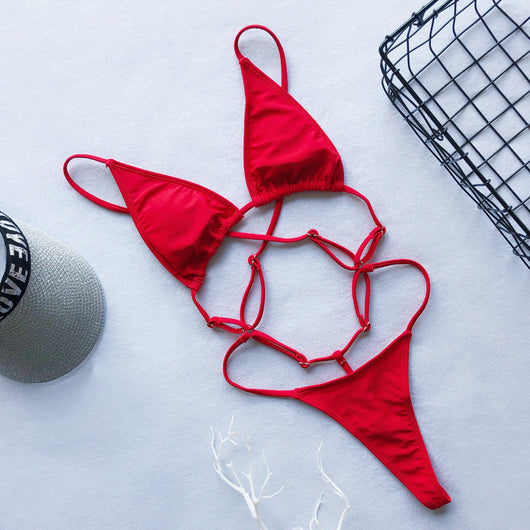 Red one-piece swimsuit with a strappy cut-out design, triangle top, and thong bottom, laid flat. - Image 16