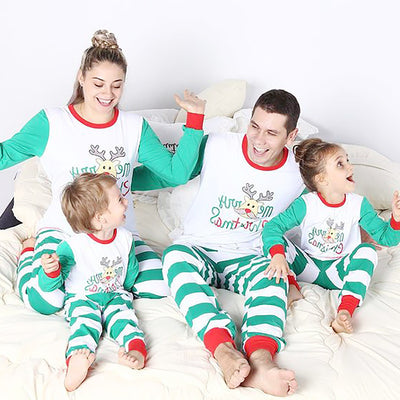 Family of four wearing matching green and white striped Christmas pajamas with a reindeer and "Merry Christmas" text.