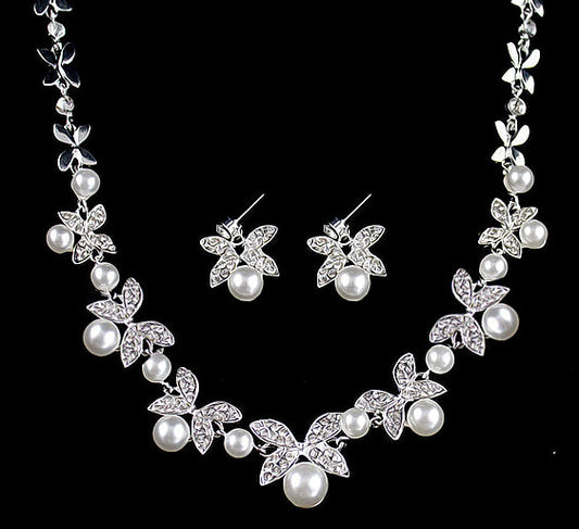 Silver-tone necklace and stud earrings set with butterfly-like motifs, clear rhinestones, and white faux pearls.