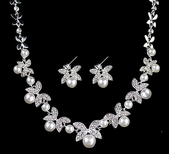 Silver-tone necklace and stud earrings set with butterfly-like motifs, clear rhinestones, and white faux pearls.