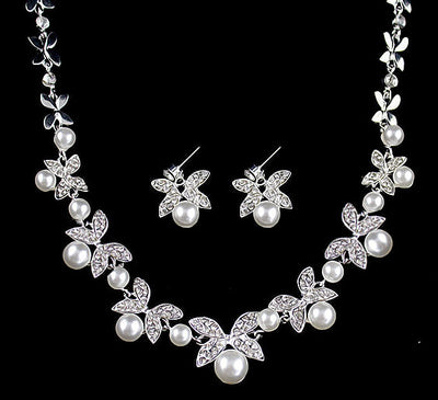 Silver-tone necklace and stud earrings set with butterfly-like motifs, clear rhinestones, and white faux pearls.