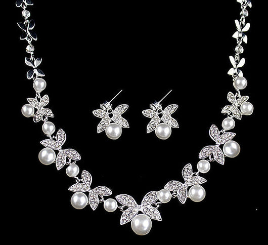 Silver-tone necklace and stud earrings set with butterfly-like motifs, clear rhinestones, and white faux pearls.
