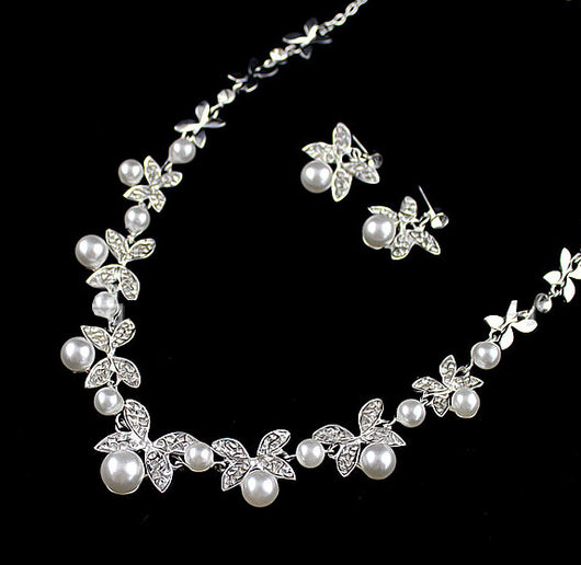 Silver-tone necklace and stud earrings set with butterfly-like motifs, clear rhinestones, and white faux pearls. - Image 3