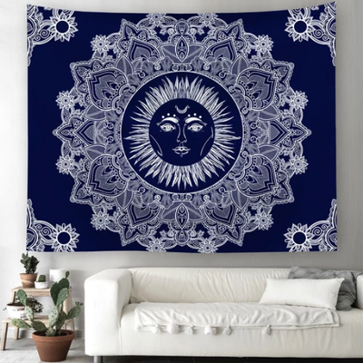 Blue traditional sun god tapestry with a white mandala design, hanging above a white sofa in a living room.