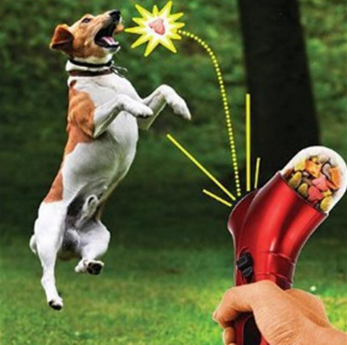 Red pet treat launcher with a clear reservoir filled with brown kibble, shown from side and top views with dimensions.