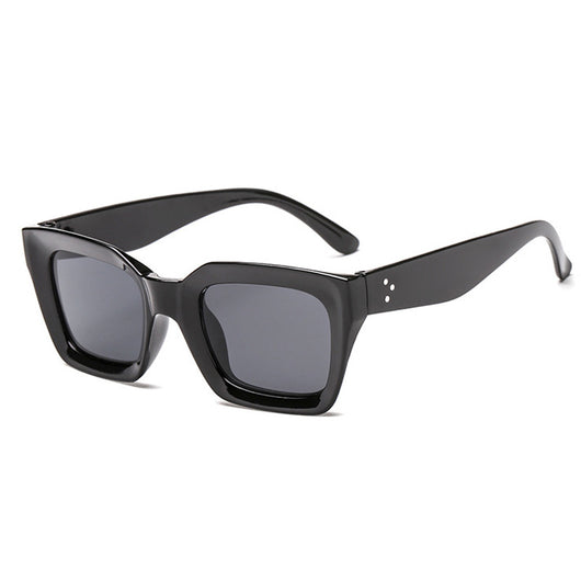 Black vintage-style sunglasses with thick plastic frames and dark rectangular lenses, featuring a subtle cat-eye shape.