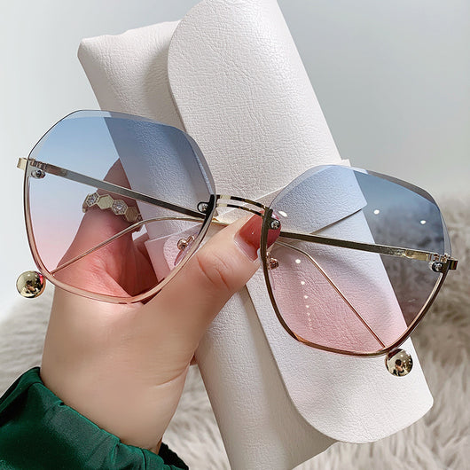 Elegant fashion sunglasses with gold metal frames and pink gradient lenses, held against a white case. - Image 11