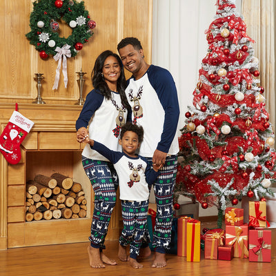 Family of three wearing matching Christmas pajamas with reindeer tops and snowflake-patterned pants. - Image 4