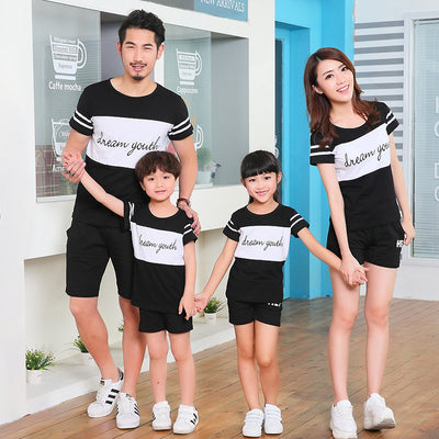 Young girl in a white short-sleeve t-shirt with a black stripe and black shorts, wearing a black cap. - Image 3