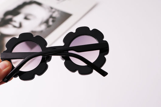 Light blue flower-shaped sunglasses with dark lenses, featuring a playful design and plastic frame. - Image 5