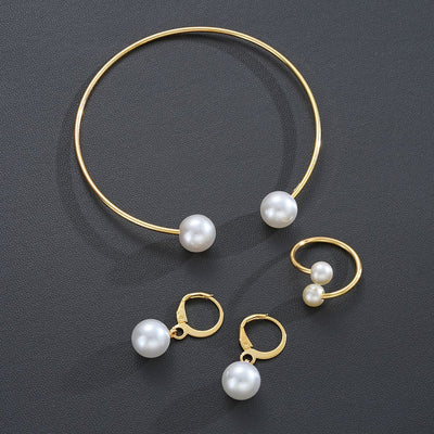 Gold-tone open cuff bracelet, matching open ring, and dangle earrings, all featuring white faux pearls. - Image 4
