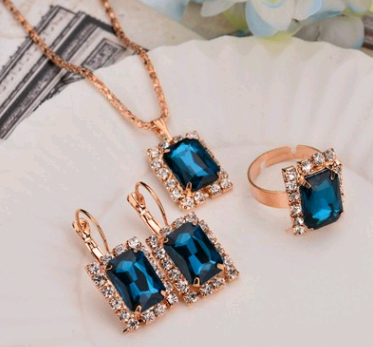 Rose gold-toned necklace, earrings, and ring set with large oval clear gemstones surrounded by smaller stones. - Image 10