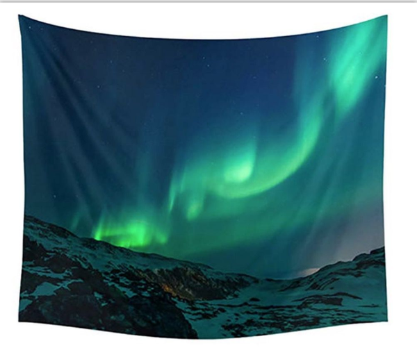 Digital print tapestry featuring the green and blue Northern Lights over a snow-covered mountain landscape at night.