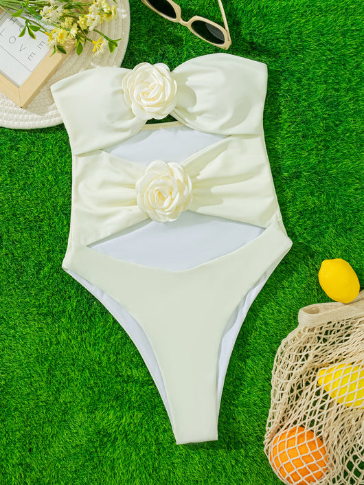 White strapless one-piece swimsuit with 3D flower details and side cut-outs, worn by a woman by an infinity pool. - Image 14