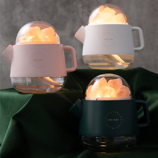 Pink kettle-shaped mini USB humidifier with a clear dome top filled with pink salt crystals, emitting mist.