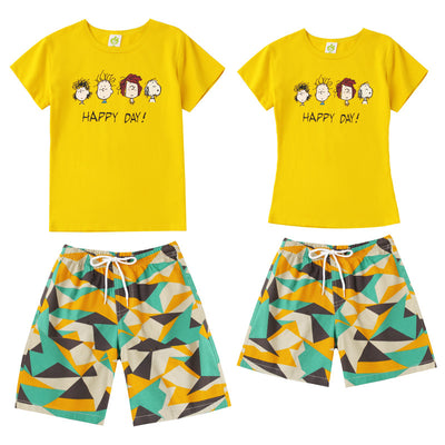 Family of four wearing matching yellow short-sleeved t-shirts with 'HAPPY DAY!' and geometric print shorts on a beach. - Image 6