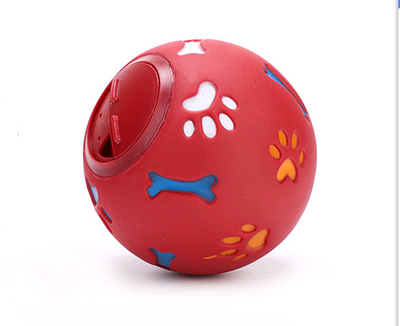 Red rubber pet puzzle ball with white, blue, and orange paw print and bone cutouts, featuring a treat dispenser opening. - Image 6
