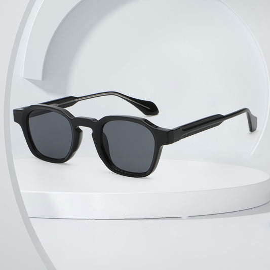 Classic fashion sunglasses with a black and tortoiseshell quadrilateral frame and dark green lenses, angled view.