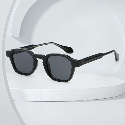 Classic fashion sunglasses with a black and tortoiseshell quadrilateral frame and dark green lenses, angled view.
