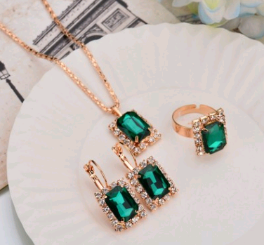 Rose gold-toned necklace, earrings, and ring set with large oval clear gemstones surrounded by smaller stones. - Image 27