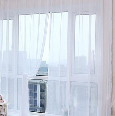 Close-up of a solid red sheer tulle curtain hanging in front of a window, allowing light to filter through. - Image 44