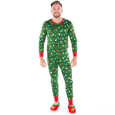 Woman wearing a green one-piece pajama suit with a colorful Christmas lights pattern and red cuffs, paired with festive slippers. - Image 10