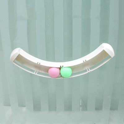 White curved track cat toy with green and pink balls, mounted on a blue wall, with two cats playing. - Image 5