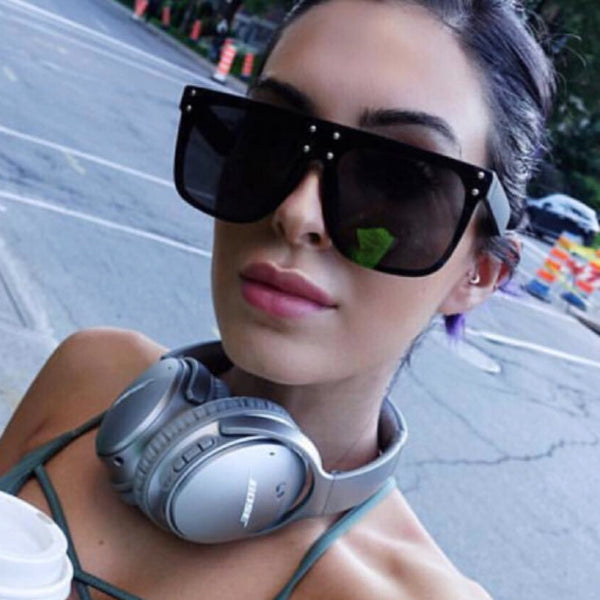 Black and white flat top sunglasses with dark lenses and small gold-toned stud details on the frame.