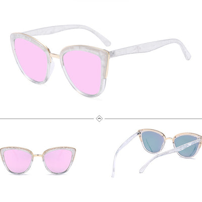 Female cat-eye sunglasses with clear marbled plastic frames, pink mirrored lenses, and gold-tone accents.