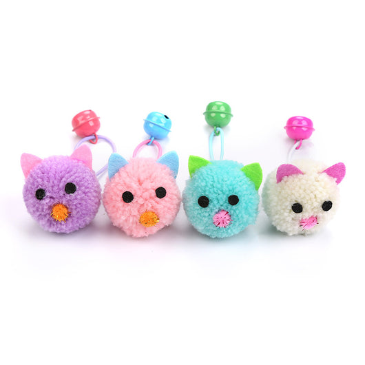 Teal plush mouse head cat toy with green ears, black eyes, pink nose, and a green bell on a light blue string.