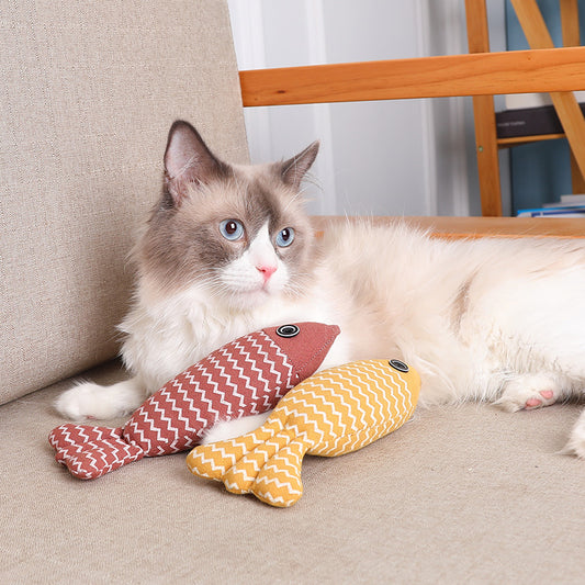 Yellow linen fish cat toy with white zigzag pattern and black and white eye detail on a white background.
