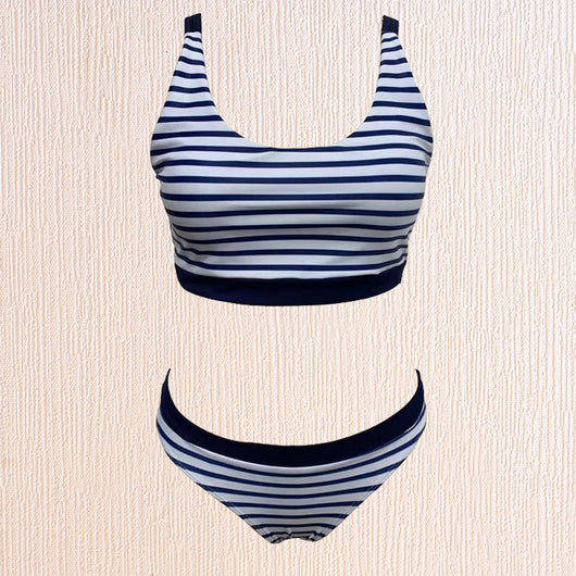 Woman smiling on a beach wearing a navy and white striped two-piece bikini with a racerback top. - Image 5